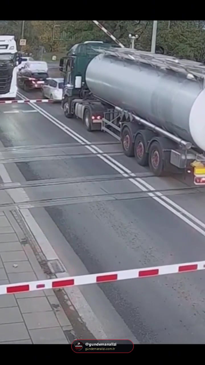 Polonya’da trafik sıkışıklığı nedeniyle hemzemin geçitte mahsur kalan tanker, bariyerlerin kapanmasıyla raylarda sıkıştı. Sürücü, yaklaşan trenden kurtulmak için bariyeri kırarak son saniyelerde geçitten çıktı.